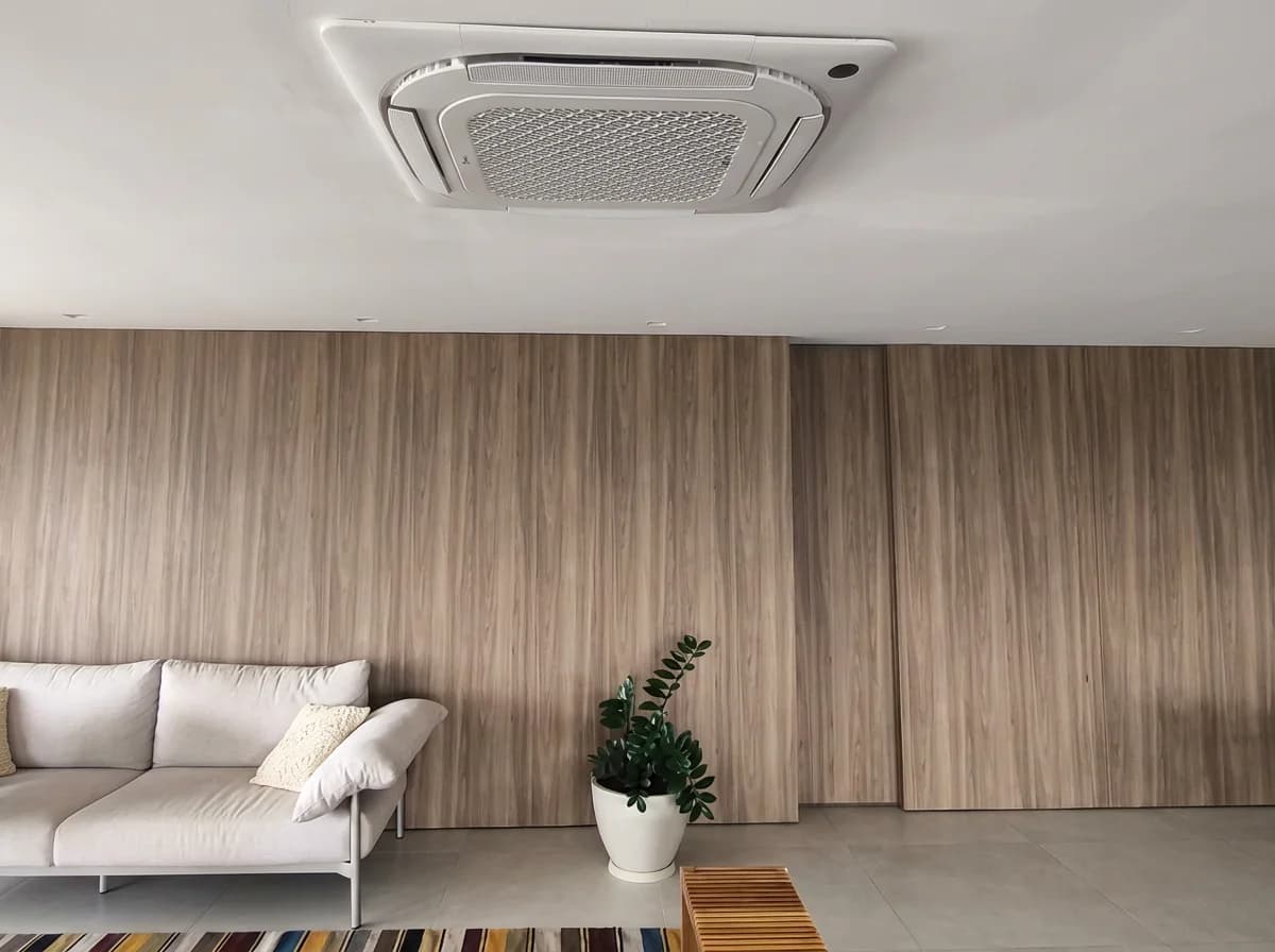 Cassete 4 vias em sala com sofá e plantas — ambiente residencial